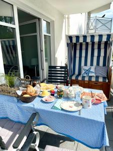 a table with a blue and white table cloth with food on it at MeerZeit - Haus Atlantic in Grömitz +17 photos