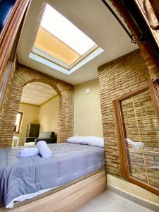 a bedroom with a large bed in a brick wall at Apartamentos Abeto in Ronda