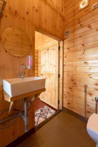a bathroom with a sink in a wooden wall at Bayview Resort in Anjuna