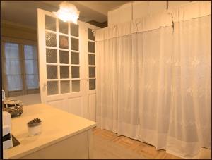 a kitchen with white curtains and a window at Tolosa un mundo de sensaciones in Tolosa