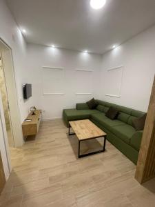 un salon avec un canapé vert et une table dans l'établissement Apartments KinGs, à Petrovac na Moru 14 autres photos