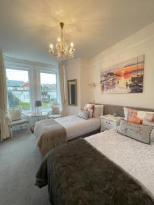 a bedroom with two beds and a chandelier at Trefoil Guest House in Brixham