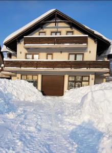 uma casa com muita neve à frente em Apartman Malnar Lokve em Lokve