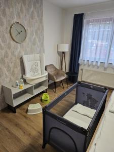 uma sala de brinquedos com um berço e uma cadeira em Hotel Restovna em Jíloviště