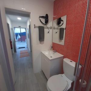 y baño con aseo, lavabo y azulejos rojos. en Casa Rural "Casa da Professora" - Meãs, Pampilhosa da Serra, en Pampilhosa da Serra