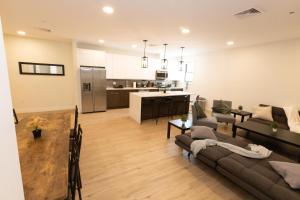 een woonkamer met een bank en een keuken bij Spacious 3-BR Luxury Suite near New York City in Union City