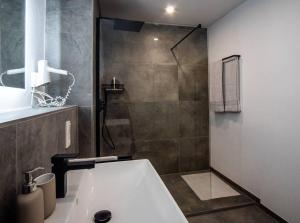 uma casa de banho com um chuveiro e uma banheira branca em Neue Fewo mit Schlossblick - Urlaub im Wein- und Ferienort Bekond em Bekond
