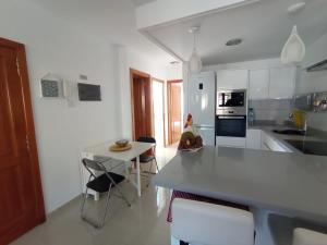 une cuisine avec un comptoir, une table et des chaises dans l'établissement El rincón de Cornelia en Tejeda, à Tejeda