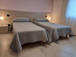 two beds in a small room with two lamps at Borgo Barucchella in Santandrà Di Povegliano +36 photos