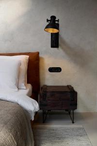 a bedroom with a bed and a lamp on the wall at Loft 16 in Iława