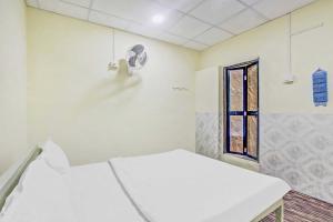 a hospital room with two beds and a window at OYO Flagship 81020 Hotel Radhe Krishna in Nagpur