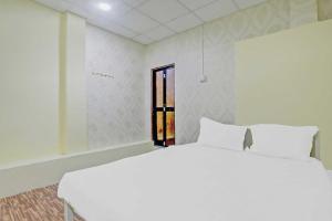 Cama blanca en habitación con ventana en OYO Flagship 81020 Hotel Radhe Krishna, en Nagpur