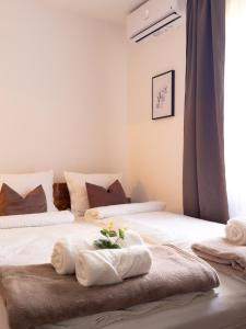 two beds with towels on them in a bedroom at Golubina 2 - Studio Apartman in Golubac