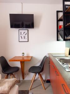 kuchnia z dwoma czarnymi krzesłami i drewnianym stołem w obiekcie Golubina 2 - Studio Apartman w mieście Golubac