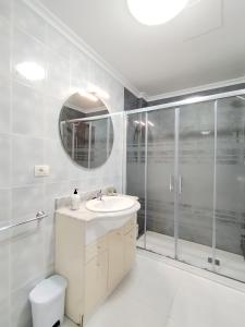 un bagno bianco con lavandino e doccia di Neboa a Viveiro Altre 21 foto