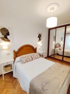 una camera da letto con un letto e un grande specchio di Neboa a Viveiro