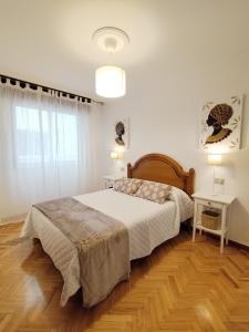 una camera da letto bianca con un letto e un tavolo di Neboa a Viveiro