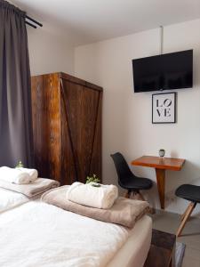1 dormitorio con 2 camas, escritorio y TV en Golubina 2 - Studio Apartman, en Golubac