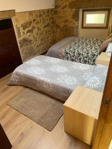 2 camas en una habitación con suelo de madera en CASA DO XABóN, en Moaña