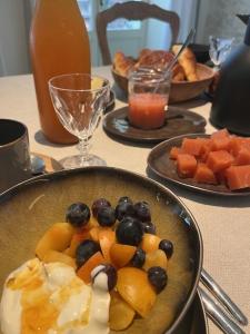 una mesa con un bol de fruta y otros platos de comida en La Grande Maurague, en Condom