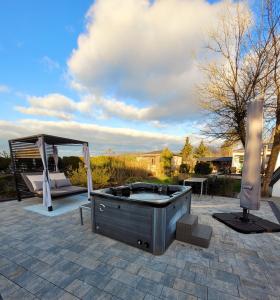 a hot tub sitting on a patio with a gazebo at Ferienhaus Grüner Bungalow & Whirlpool in Stendell