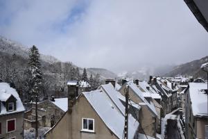 a city covered in snow with houses and mountains at T2 tout confort 1 chambre, proche hypercentre classé 2 étoiles in Le Mont-Dore