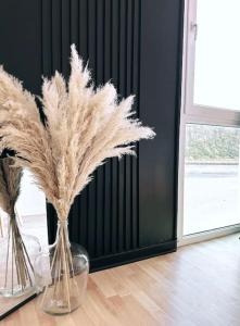 two vases with feathers in them sitting on a floor at Appartement vue sur mer in Plérin