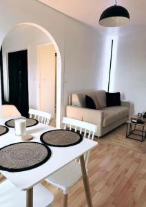 uma sala de estar com uma mesa e cadeiras e um sofá em Appartement vue sur mer em Plérin