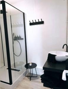 a bathroom with a shower and a tub and a sink at Appartement vue sur mer in Plérin