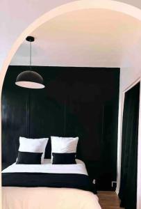 um quarto com uma cama com uma cabeceira preta em Appartement vue sur mer em Plérin