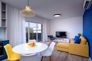 a living room with a table and a yellow couch at Modern, 2 bedroom apartment in Hvar