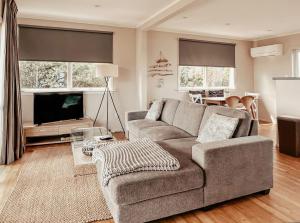 a living room with a couch and a tv at Beachfront Retreat On Revell in Hokitika
