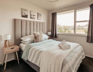 a bedroom with a bed with two towels on it at Beachfront Retreat On Revell in Hokitika