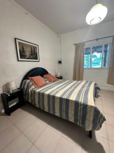 um quarto com uma cama com um cobertor listrado em A CAZON QUITADO em Saladillo