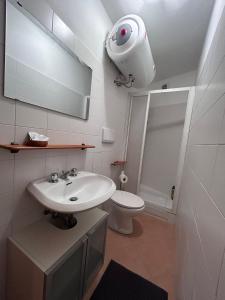 La salle de bains est pourvue d'un lavabo blanc et de toilettes. dans l'établissement La Casetta, à Moneglia