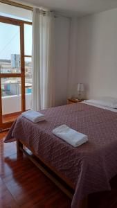 1 dormitorio con 1 cama con 2 toallas en El Capricho II Paracas, en Paracas