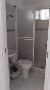 a bathroom with a toilet and a shower at HOSTAL CARACOLI - HUECO in Valledupar