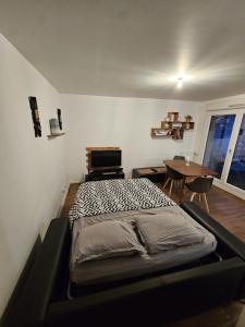 a bed in a room with a table and a window at Cosy Furnished Studio Near Paris and Stade de France in Saint-Ouen