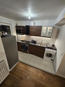 a kitchen with a sink and a washing machine at Cosy Furnished Studio Near Paris and Stade de France in Saint-Ouen