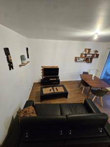 a living room with a couch and a table at Cosy Furnished Studio Near Paris and Stade de France in Saint-Ouen