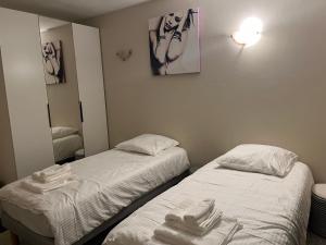 2 bedden in een kamer met witte lakens bij Appartement 3 chambre, 2 Salle de bain in Cannes