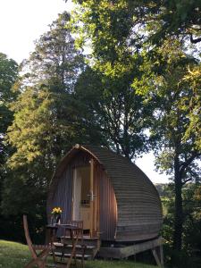 Cabaña de madera pequeña con mesa delante en birdbox@glanrhyd, en Pontardawe