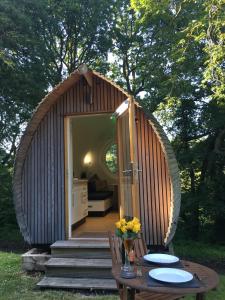 eine kleine Holzhütte mit einem Tisch und Stühlen in der Unterkunft birdbox@glanrhyd in Pontardawe