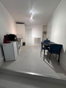 een kamer met een tafel en stoelen en een keuken bij L’insolite in Auxerre