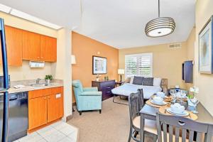 a kitchen and a living room with a table and chairs at Condo Near Universal Studios With Pool Hot Tub in Orlando