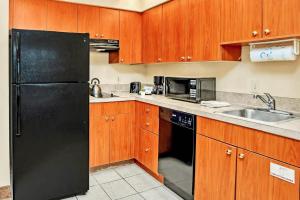 a kitchen with a black refrigerator and a sink at Condo Near Universal Studios With Pool Hot Tub in Orlando