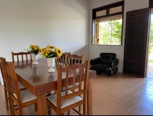 a dining room with a table and chairs with flowers on it at Chácara Amsterdam in Aracaju