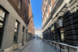 an empty street in a city with tall buildings at Apartment Fedora Old Town Sarajevo in Sarajevo