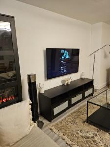 sala de estar con TV de pantalla plana en la pared en CENTRAL London Luxury APP, en Londres