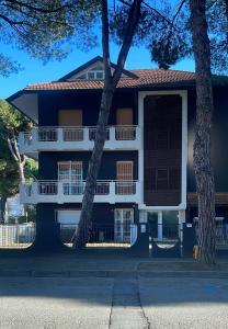 niebiesko-biały budynek z drzewami przed nim w obiekcie La Casina Del Mare w mieście Cervia